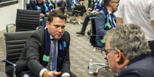 FFA chief executive James Johnson passes his phone to chairman Chris Nikou as they wait for FIFA to announce the hosts of the 2023 Women's World Cup.