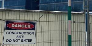 Signs warn of danger at the school construction site.