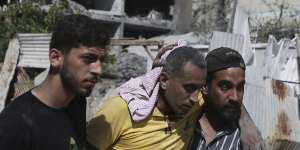 Palestinians help a wounded man after Israeli strikes in Nuseirat refugee camp this month.
