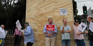 Former students and parents of students at Newington College holding protest signs at the entrance of the private boys college. 