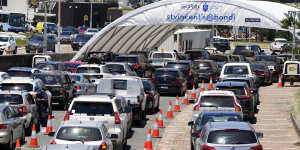 FILE - Cars line up at a drive-through COVID-19 testing clinic at Bondi Beach in Sydney on Dec. 21,2021. Australia’s most populous state recorded more than 6,000 new COVID-19 cases for the first time Saturday,Dec. 25,adding a somber note to Christmas celebrations. (AP Photo/Rick Rycroft,File)