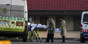 A patient is removed from St Basil's Homes for the Aged in Victoria in Fawkner on Saturday.