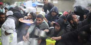 Palestinians line up for free food distribution during the ongoing Israeli air and ground offensive in Khan Younis,Gaza Strip