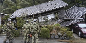 Japanese Self Defence Force members inspect a collapsed house hit by earthquakes in Suzu,Ishikawa.