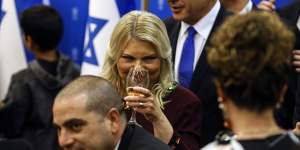 Israeli Prime Minister Benjamin Netanyahu,background,and his wife Sara,centre,toast the new speaker of the knesset,Amir Ohana,at the Knesset.