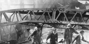 Westgate Bridge collapse,1970:A victim is carried from a massive pile of twisted girders by civil defence men and workmates. 