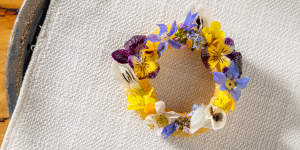 Fried pastry circle filled with horseradish and buttermilk gel,drizzled with green garlic oil and topped with edible flowers.