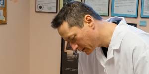 Chiropractor Rick Tsai adjusts the neck of patient Barry Sumner in Darlington.