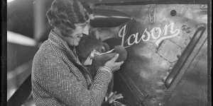 Amy Johnson holding a teddy bear,at Mascot,Sydney with her Gipsy Moth plane"Jason"ca 1930.