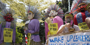 Environmental activists display posters as performers dance in traditional giant effigies called “ondel-ondel” during a climate strike rally in Jakarta on Sunday.
