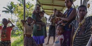 Poor families wait at a health clinic in Papua New Guinea. Australia has increased its aid spending in the region this financial year