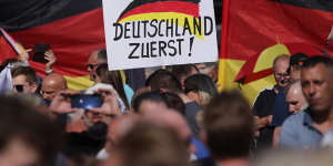 Supporters of the far-right Alternative for Germany party hold a placard that reads,“Germany First!” at a rally in Thuringia in August.