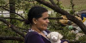 Mercedes Valdez holds her dog Kira as she waits for transportation after losing her home to Hurricane Ian in Pinar del Rio,Cuba.