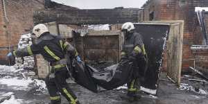 Firefighters carry a body of a resident killed in a fire as a Russian drone hit his home in a residential neighbourhood,in Kharkiv,Ukraine.