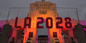 An LA2028 sign is seen in front of a blazing Olympic cauldron at the Los Angeles Memorial Coliseum.
