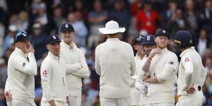 England's players watch the replay of a no-ball delivered to Steve Smith.