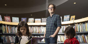 Librarian Tim Cuthell with readers Evie,5,and Sylvie,3.
