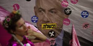 An Israeli protester wears pink during a demonstration against Israeli Prime Minister Benjamin Netanyahu outside his official residence in Jerusalem on Saturday,June 12,2021. Hebrew reads:“You failed”,” Israel free” and “Leave”.