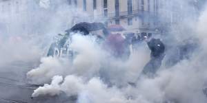 Protesters run through tear gas in Nantes,western France,on Thursday.