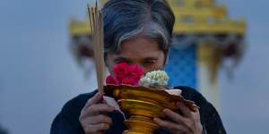 A Thai mourner prays in front of a replica of the royal crematorium in Bangkok.