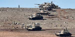 Turkish tanks line up on a hill outside the village of Mursitpinar next to the Syrian town Kobane.