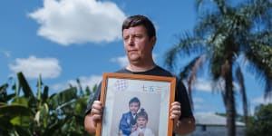 David Fleming holds a picture of his abducted children at his rural property outside of Brisbane.