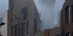 NSW Fire and Rescue workers spray water onto the destroyed building.