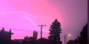 Pink sky above Melbourne as electrical storm lights up the city