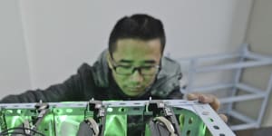 A staff member checks a bitcoin mining computer at the bitcoin mining company Landminers in southwestern China’s Chongqing Municipality.