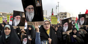 Demonstrators in Tehran hold up portraits of Supreme Leader Ayatollah Ali Khamenei during a pro-government rally denouncing last week’s violent protests over a fuel price hike.