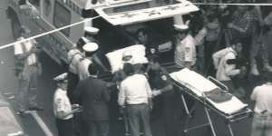 Ambulance workers and police surround a victim of the Queen Street Shooting before they're loaded into an ambulance.