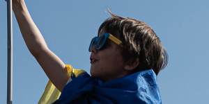 A boy holds a Ukrainian flag atop a Russian tank displayed in Kyiv ahead of Independence Day.