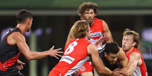 Essendon’s Dylan Shiel is tackled by James Rowbottom and Callum Mills of the Swans last Saturday night. 