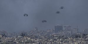 Gazans have many reasons to seek refuge. Parachutes drop supplies into the northern Gaza Strip,as seen from southern Israel on Wednesday. 
