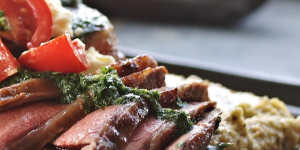 Spiced lamb slices resting on a bed of creamy white bean puree,scattered with spiced herb gremolata.