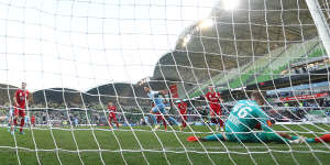 Jamie Maclaren of Melbourne City beats Adelaide United goalkeeper Joe Gauci to score.