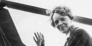American aviator Amelia Earhart,the first woman to complete a solo transatlantic flight,waves as she emerges from the cockpit of a rotorcraft,Newark,New Jersey,circa 1935.