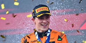 Race winner Oscar Piastri of Australia and McLaren celebrates on the podium.