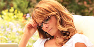 Beautiful mature woman sitting in the garden and working at home. Working from home generic