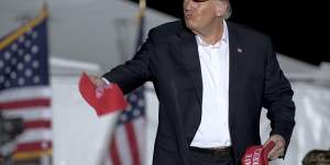 Former president Donald Trump throws hats to supporters at a rally,Saturday in Robstown,Texas.