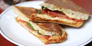 Pressed focaccia with'nduja,smoked mozzarella,tomato and basil.