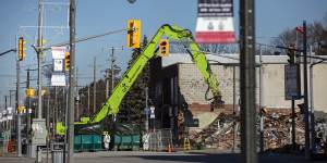 A crew works to demolish a building next to the site of last summer’s gas explosion in Wheatley,Ontario.
