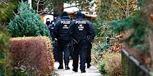 Police walk to a residence that they raided earlier today in Berlin,Germany.
