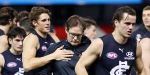 Charlie Curnow,left,consoles Carlton coach David Teague,centre,during round 23. 