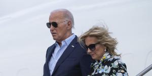 US First Lady Jill Biden holds President Joe Biden’s hand and they descend from Air Force One.