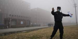 A security official moves journalists away from the Wuhan Institute of Virology after a World Health Organisation team arrived for a field visit in Wuhan in China’s Hubei province on February 3,2021.