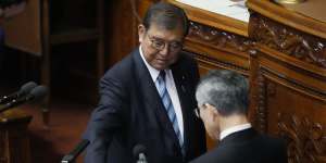 Japanese Prime Minister Shigeru Ishiba,left,votes for a run-off for a new prime minister on Monday. 