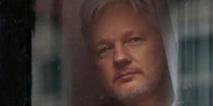 Julian Assange looks out a window of the Ecuadorian embassy in London,where he stayed for nearly seven years.