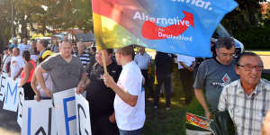 Supporters of the Alternative for Germany party hold a flag proclaiming"Our country,our homeland"