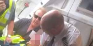 Jetstar passenger Barry Clark (centre) and a pilot wrestle the armed teen to the floor of the plane.